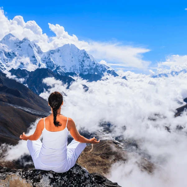 girl meditating on mountain on yoga trekking with yoloo.life