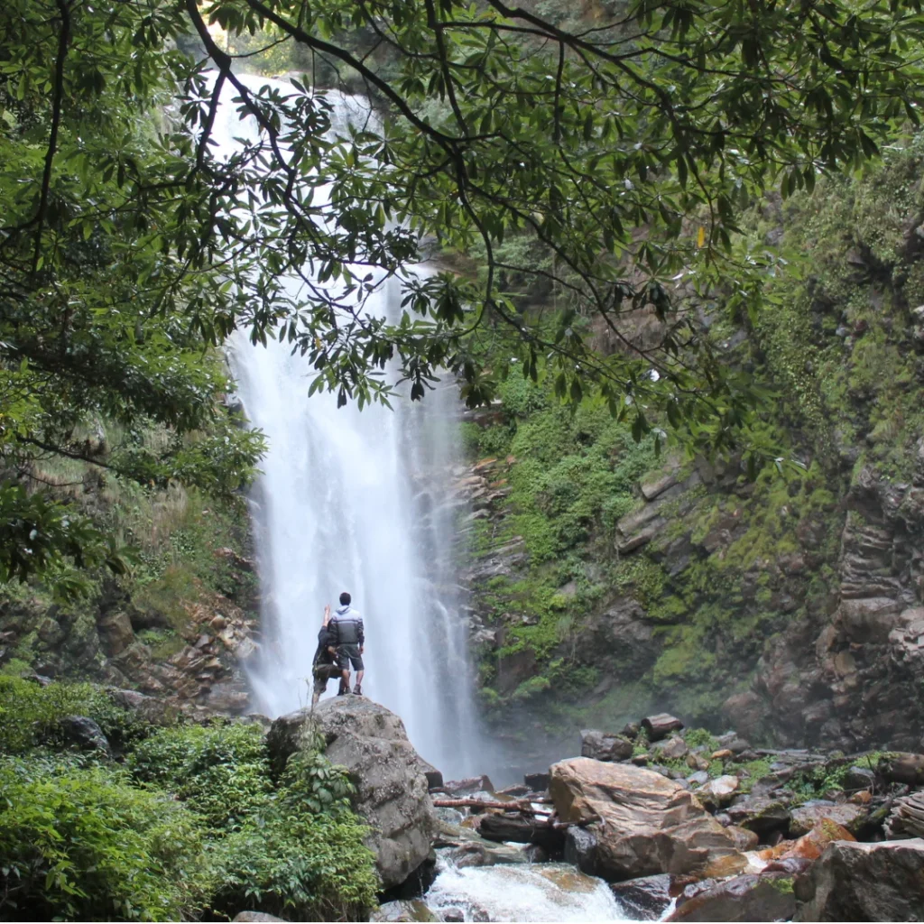 2 people in front of a huge waterfall