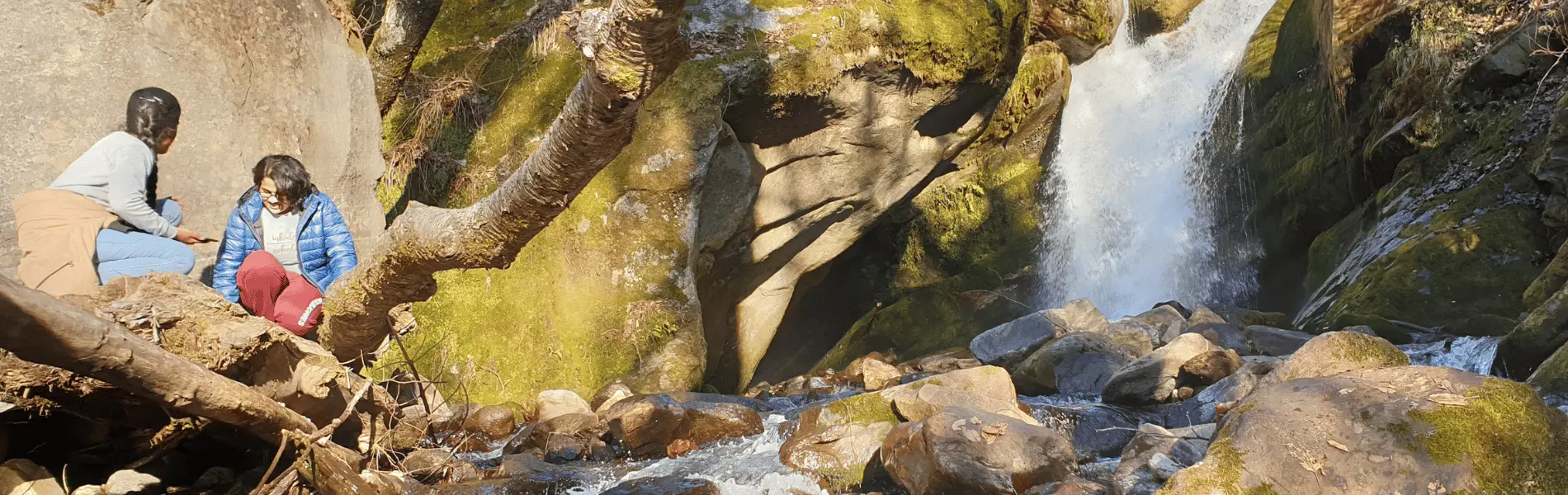 2 girls in front of Crystal Falls at VanVaas Art Retreat in Soil (Soyal) village, manali